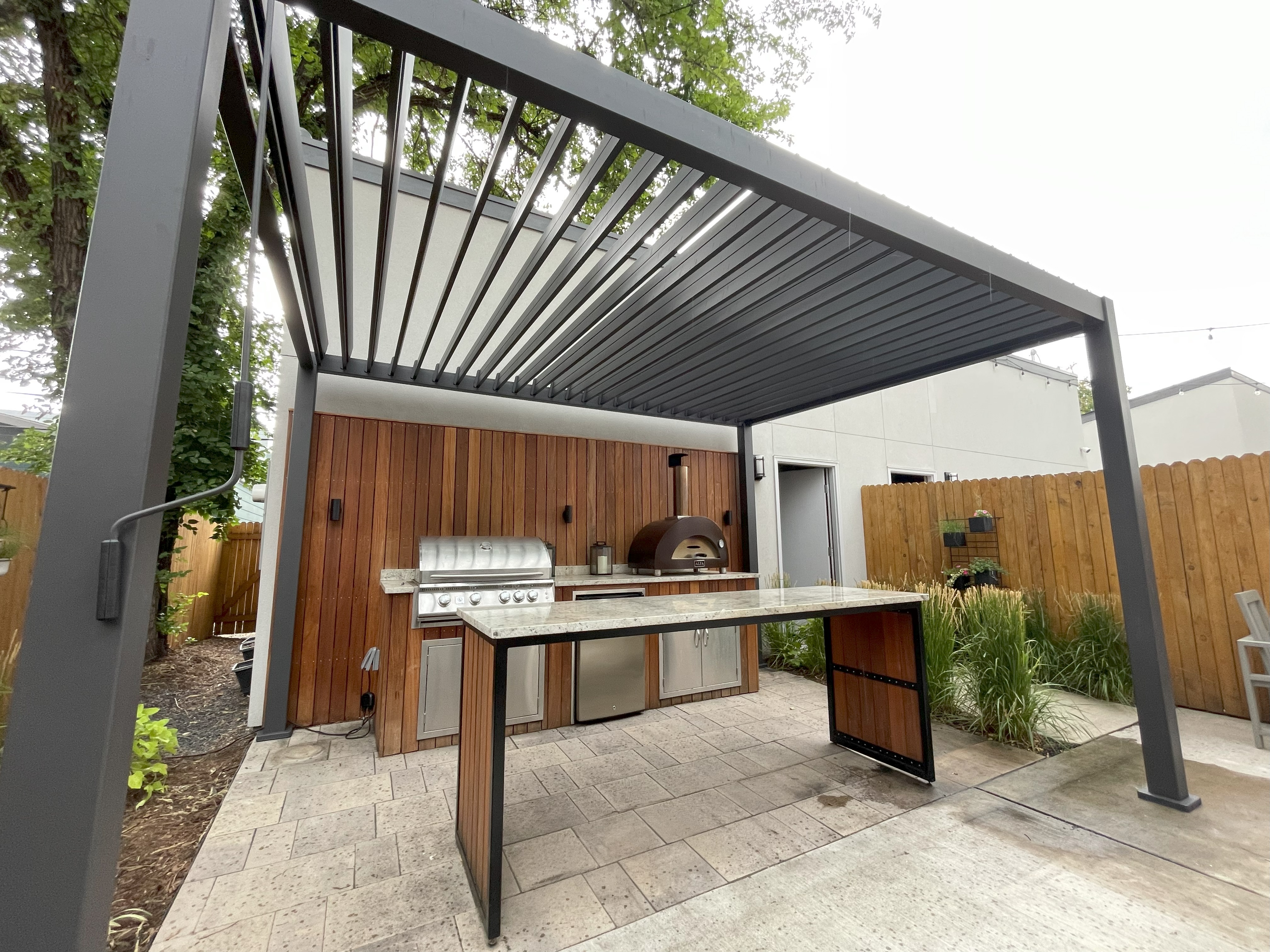 Modern louvered pergola with adjustable roof and outdoor kitchen